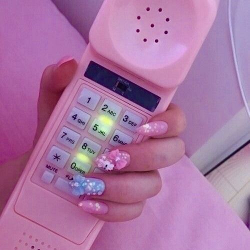Pink 90s/00s telephone with lights being held by a white women with pretty pink/purple nails